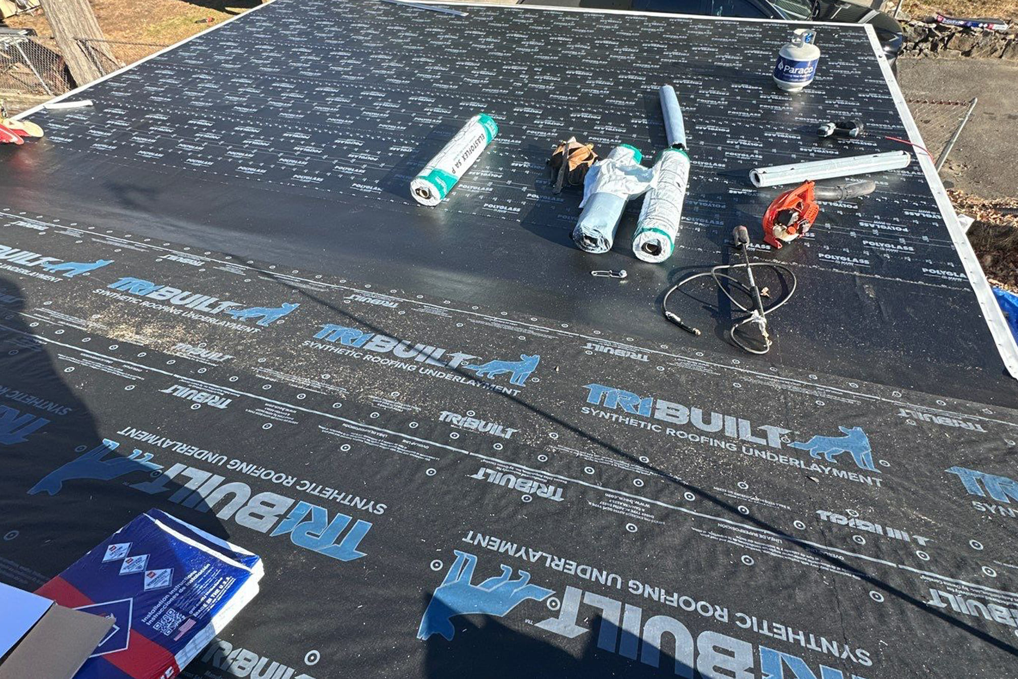 Residential roof replacement with workers removing old shingles